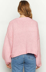 Rear view of a sorbet pink chunky knit cardigan with dropped shoulders and a ribbed hem