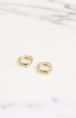 Gold hoop earrings with diamante stars and star cutouts on the inner edge, viewed from above
