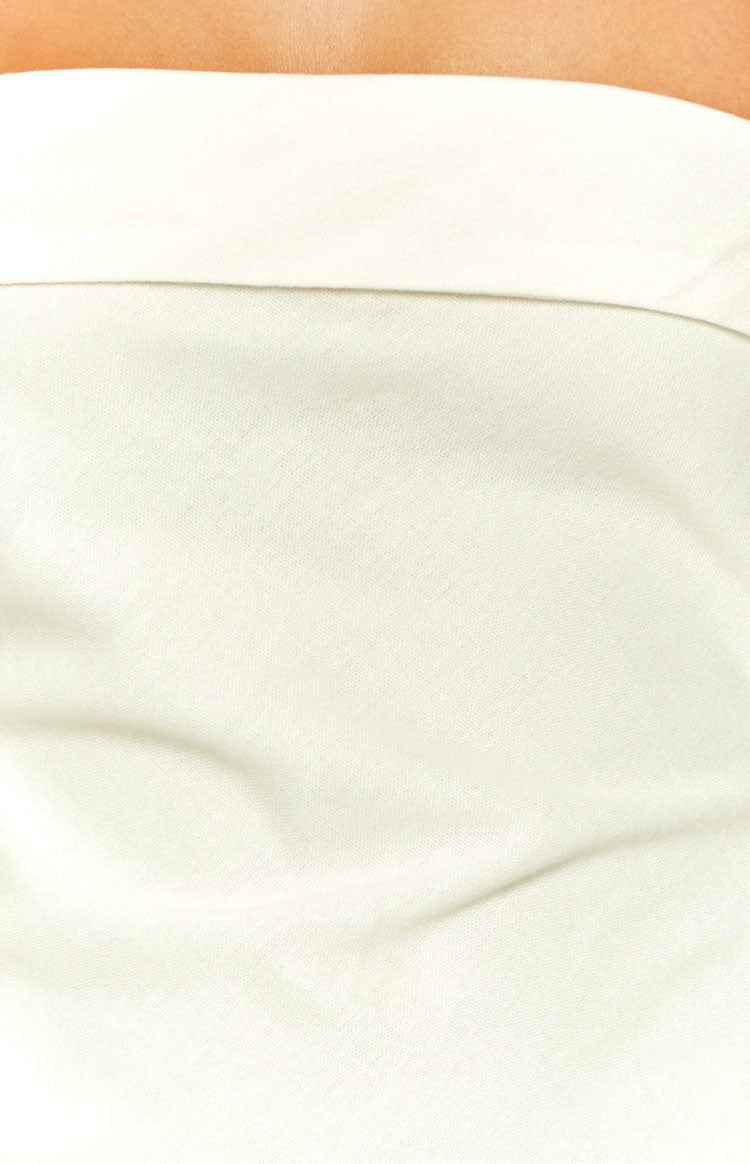Close-up of the cream woven fabric texture and subtle draping of the midi dress