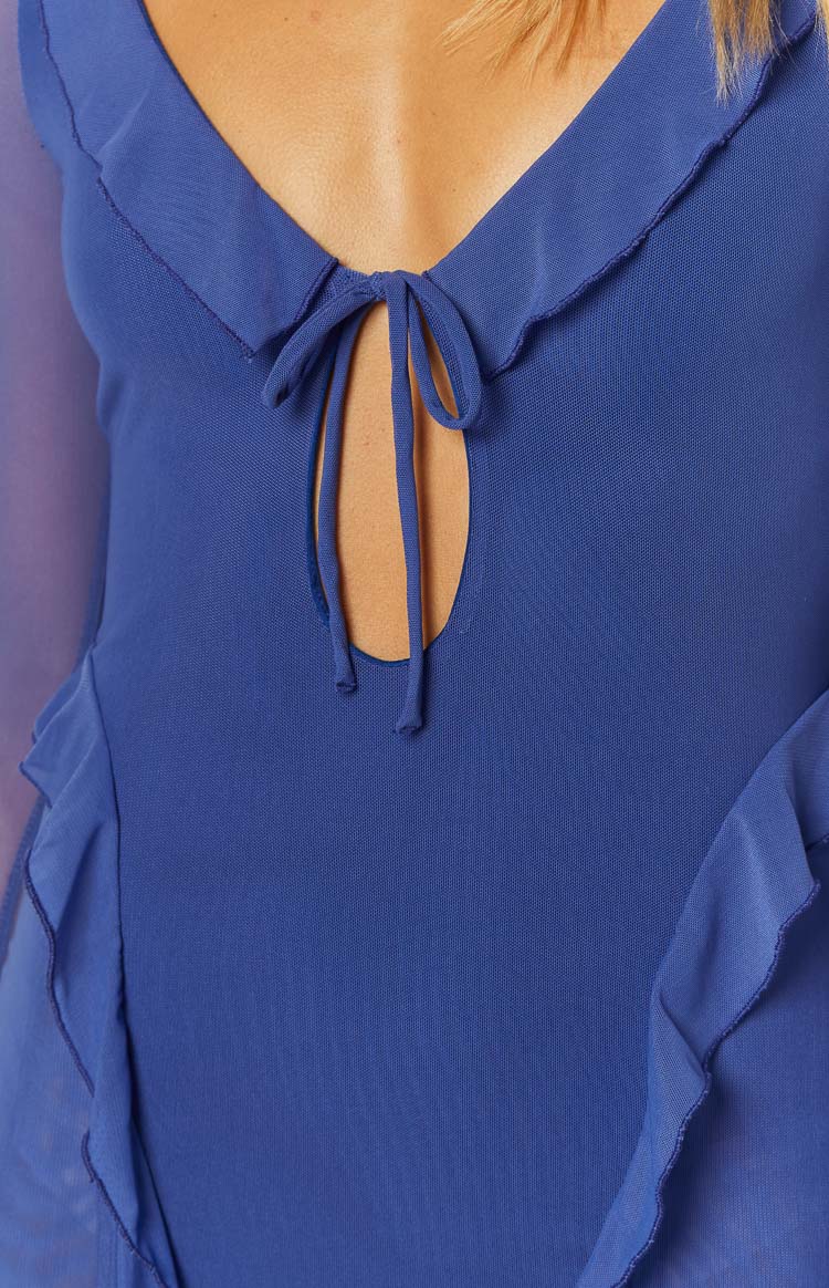 Close-up of the blue mesh mini dress showing the V-neck with ruffle trim, front keyhole cutout, and self-tie bust