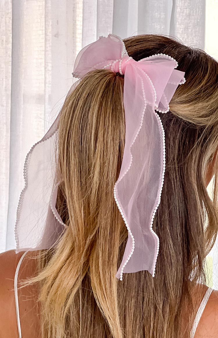 blonde girl wearing a sheer pink clip on bow