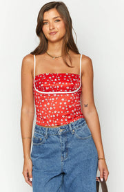 Red floral crop top featuring a square neckline, thin white spaghetti straps, and white underbust piping