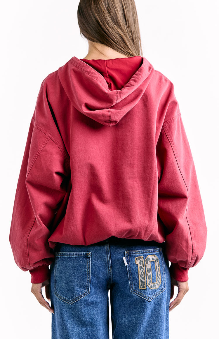The back view of a red oversized hoodie showcasing the back of the hood and the loose fit.