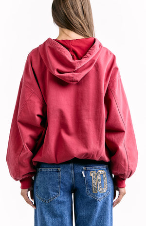 The back view of a red oversized hoodie showcasing the back of the hood and the loose fit.