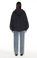 Rear view of a washed navy oversized hooded jacket with an elasticated hem and cuffs, showing seam details