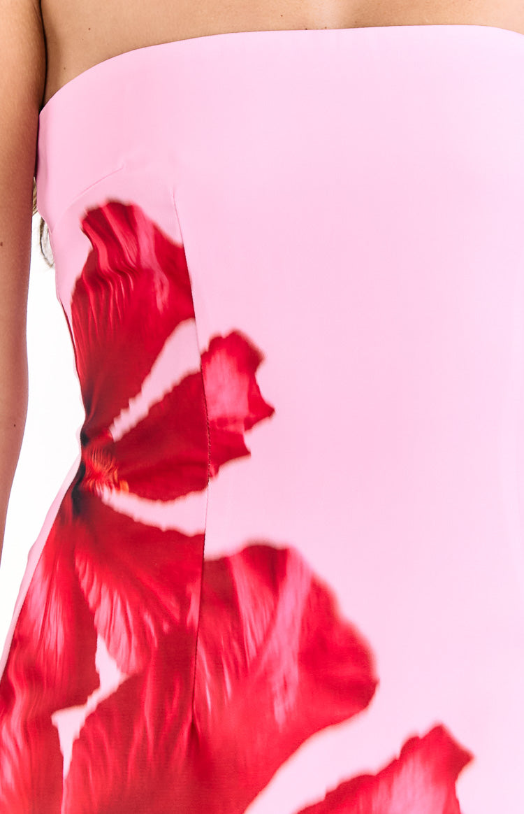 Close-up of the side seam on a pink strapless mini dress, showing the red hibiscus print