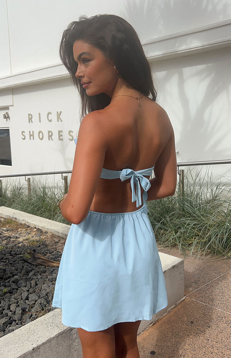 Rear view of a light blue strapless mini dress with a back tie closure and elasticated waist