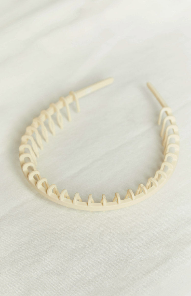 Cream plastic headband with a full row of small, rounded teeth along the inner edge