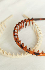 Close-up of the cream and tortoiseshell headbands showing the comb teeth detail