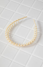 Cream plastic headband showing the full comb-like teeth structure on the inner edge