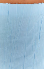 Close-up showing the light blue crinkled texture of the maxi skirt and the ruffled elastic waistband