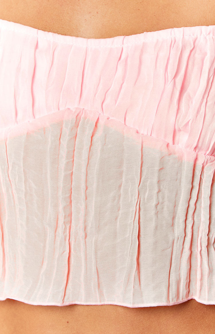 Side view of a pink crinkled cami top with thin spaghetti straps and a cropped hem