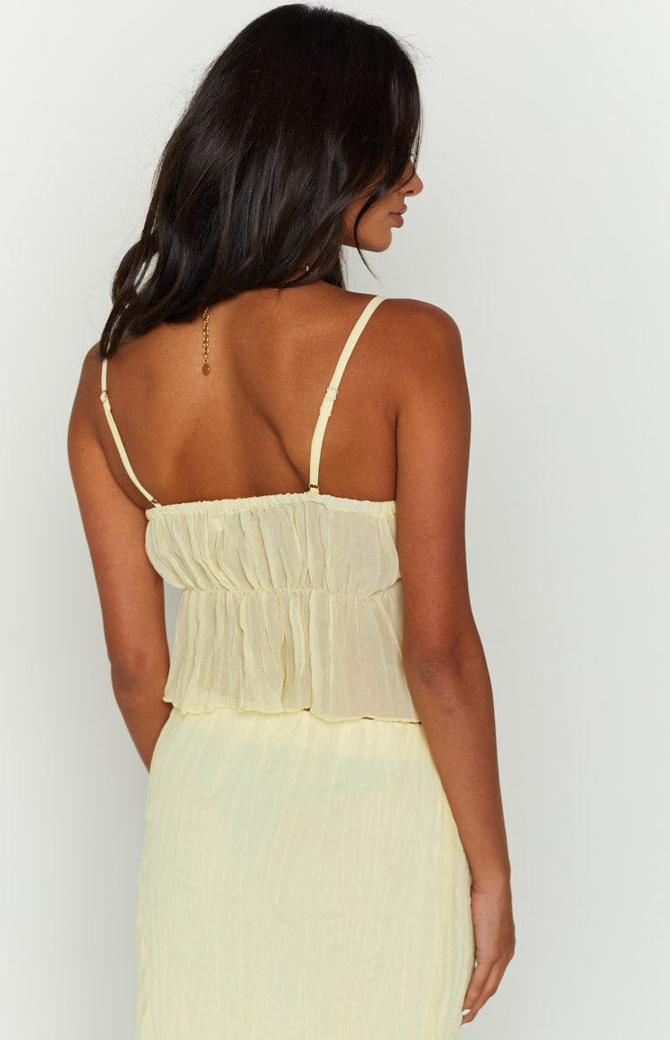 Rear view of a yellow crinkled cami top with thin adjustable spaghetti straps and an elasticated gathered back