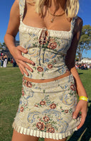 Beige tapestry mini skirt with a floral pattern and a ruffled hem