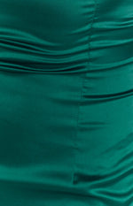 Close-up of the emerald green satin fabric with ruched detailing and vertical stitching