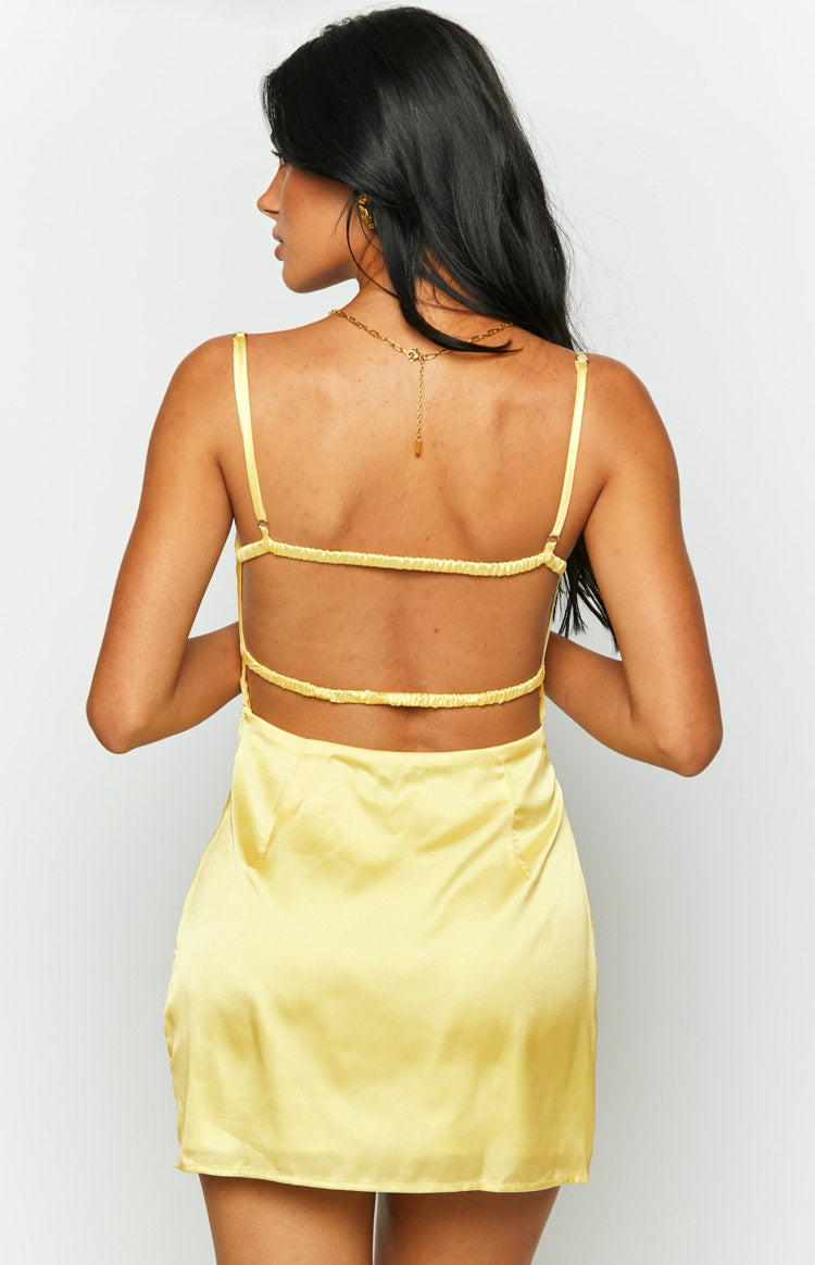 Rear view of a yellow satin mini dress with a low open back and three horizontal elasticated straps