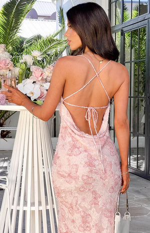 Rear view showing the cowl back, criss-cross tie straps, and pink butterfly pattern of a maxi dress