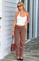 Full length front view of brown carrot fit jeans with a high waist, button fly, and relaxed tapered leg