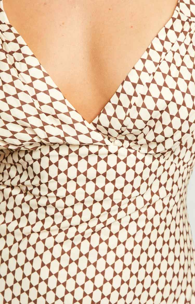 Close-up of the beige and brown geometric pattern on the V-neckline and ruched bodice of a maxi dress