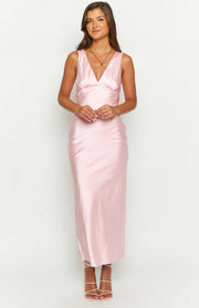 Front view of a light pink satin maxi dress with a V-neck, fitted ruched bust, and a flowing skirt