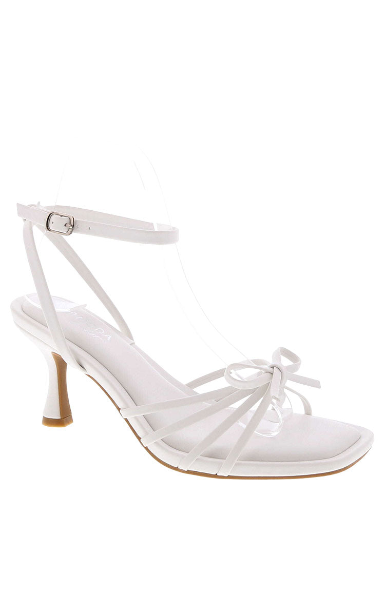 A pair of white strappy stiletto heels with a delicate front bow detail and a square toe.