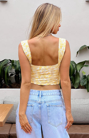 Rear view of a yellow and white lace crop top with a square back neckline