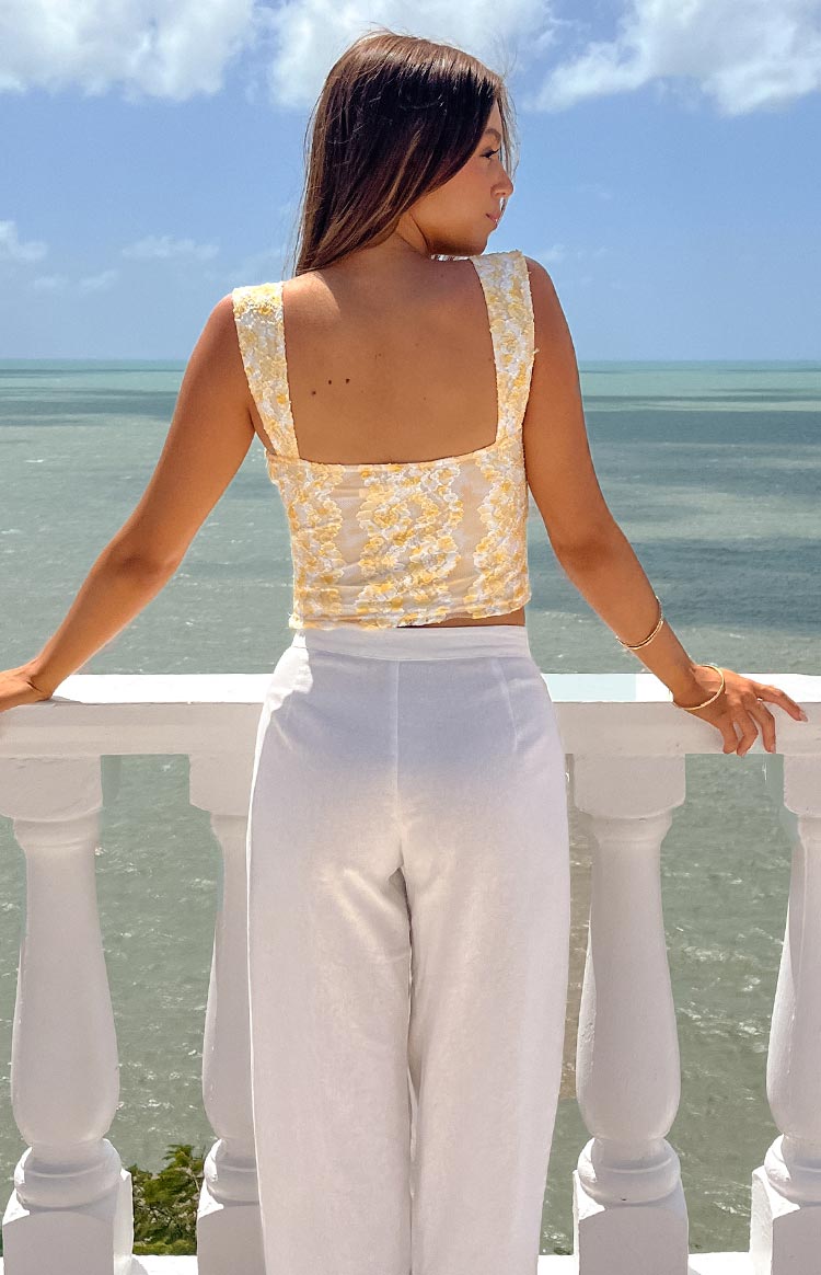 Rear view of a yellow and white floral lace crop top with a square back and wide straps