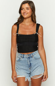 Black crinkled top with white bow tie shoulder straps and a square neckline