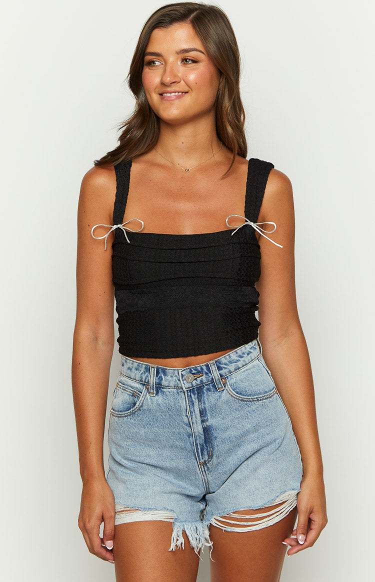 Black crinkled top with white bow tie shoulder straps and a square neckline