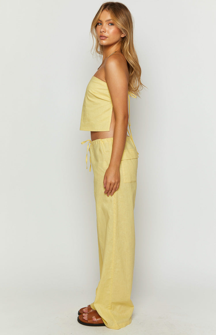 Side view of yellow wide-leg pants with a drawstring waist and a side patch pocket, linen-look fabric