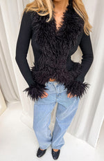 Black ribbed knit cardigan with shaggy fur trim along the V-neckline, front opening, and cuffs