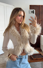 Close-up of the beige ribbed knit cardigan with shaggy fur trim on the V-neckline and cuffs