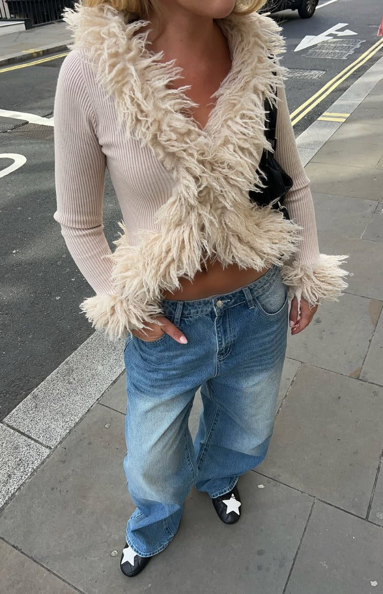 Beige ribbed knit cropped cardigan with shaggy fur trim framing the V-neckline and cuffs
