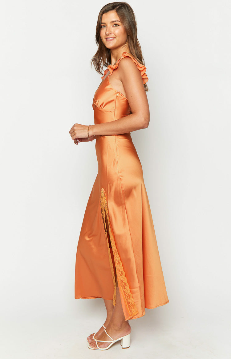 Side view of an orange satin maxi dress with ruffled shoulder straps and a high side slit revealing lace trim