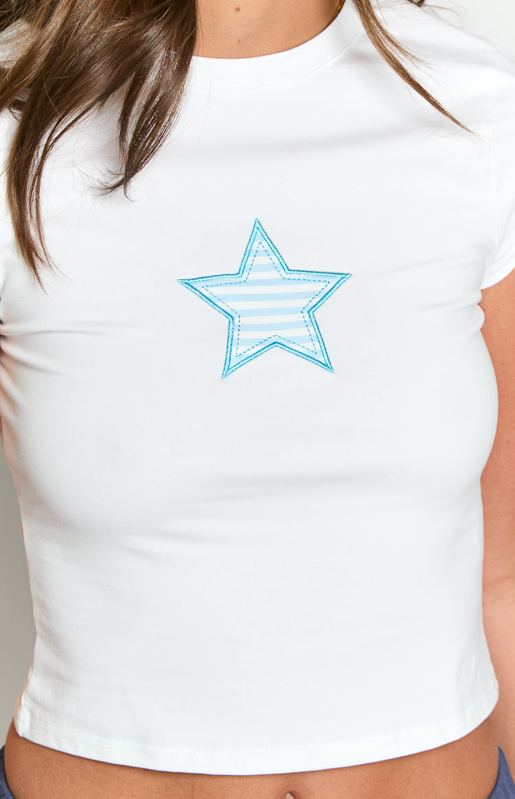 Close-up of the embroidered blue star with light blue horizontal stripes and a double stitched outline on a white baby tee