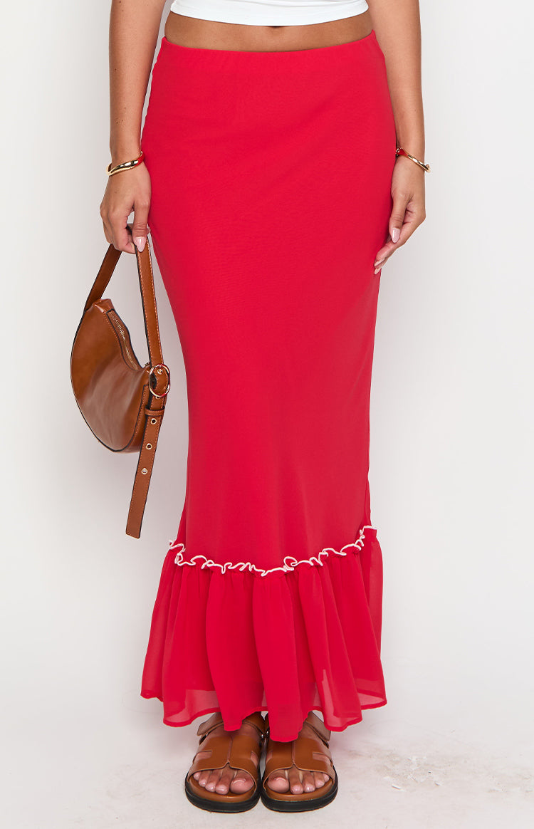 Lower section of a red maxi skirt, highlighting the sheer ruffled hem with white wavy trim