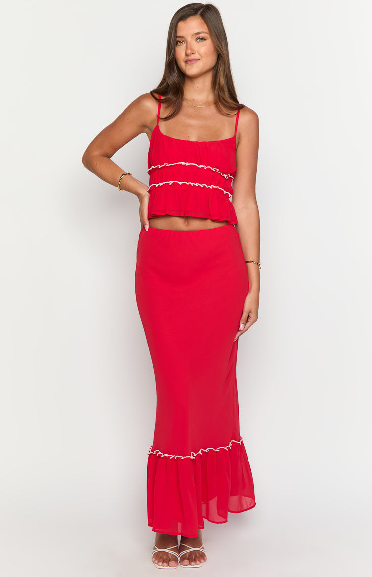 Full length view of a red maxi skirt with a fitted silhouette and a ruffled hem with white trim