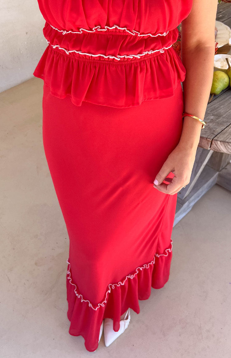 Red maxi skirt with a fitted silhouette and a ruffled hemline featuring white trim