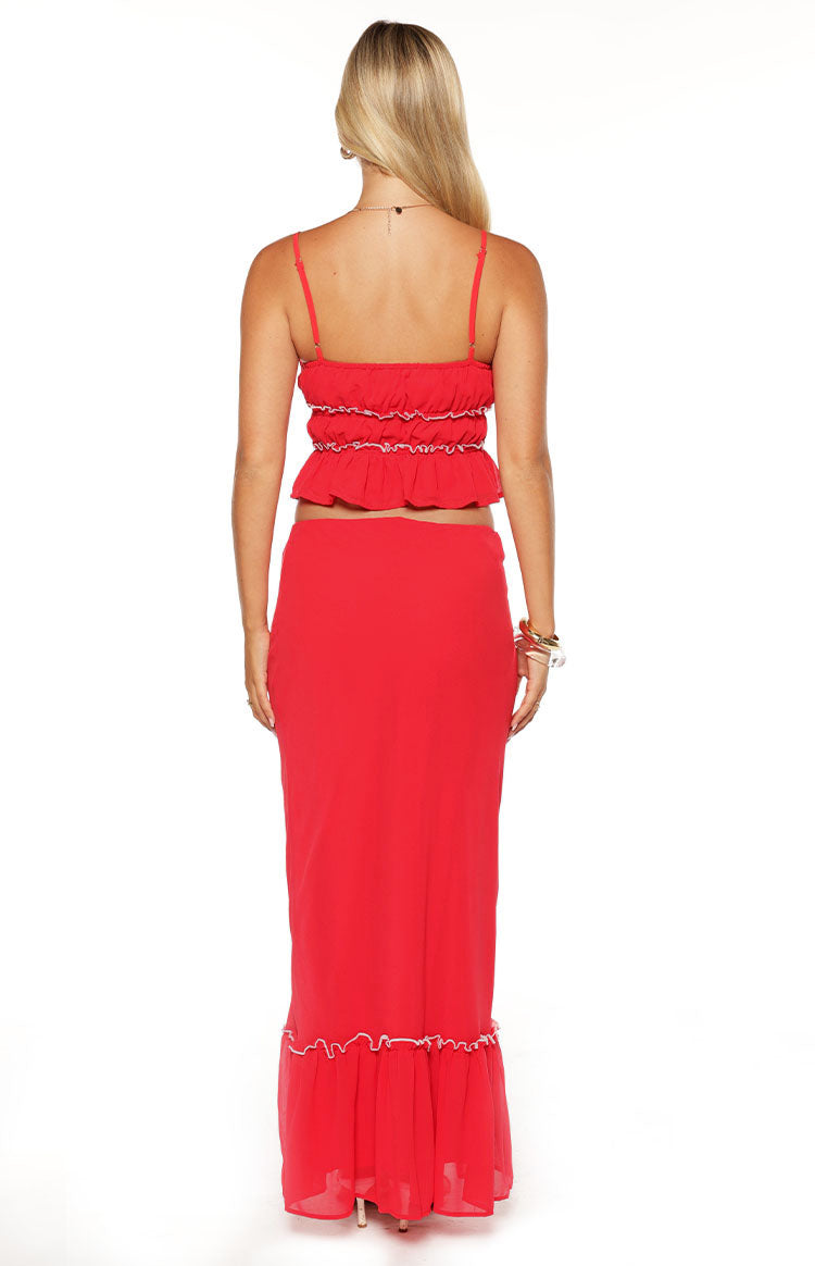 Rear view of a red maxi skirt with a ruffled hem and white trim
