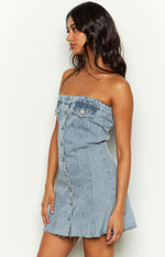 Side view of a light blue denim strapless mini dress with button-front closure and chest pockets