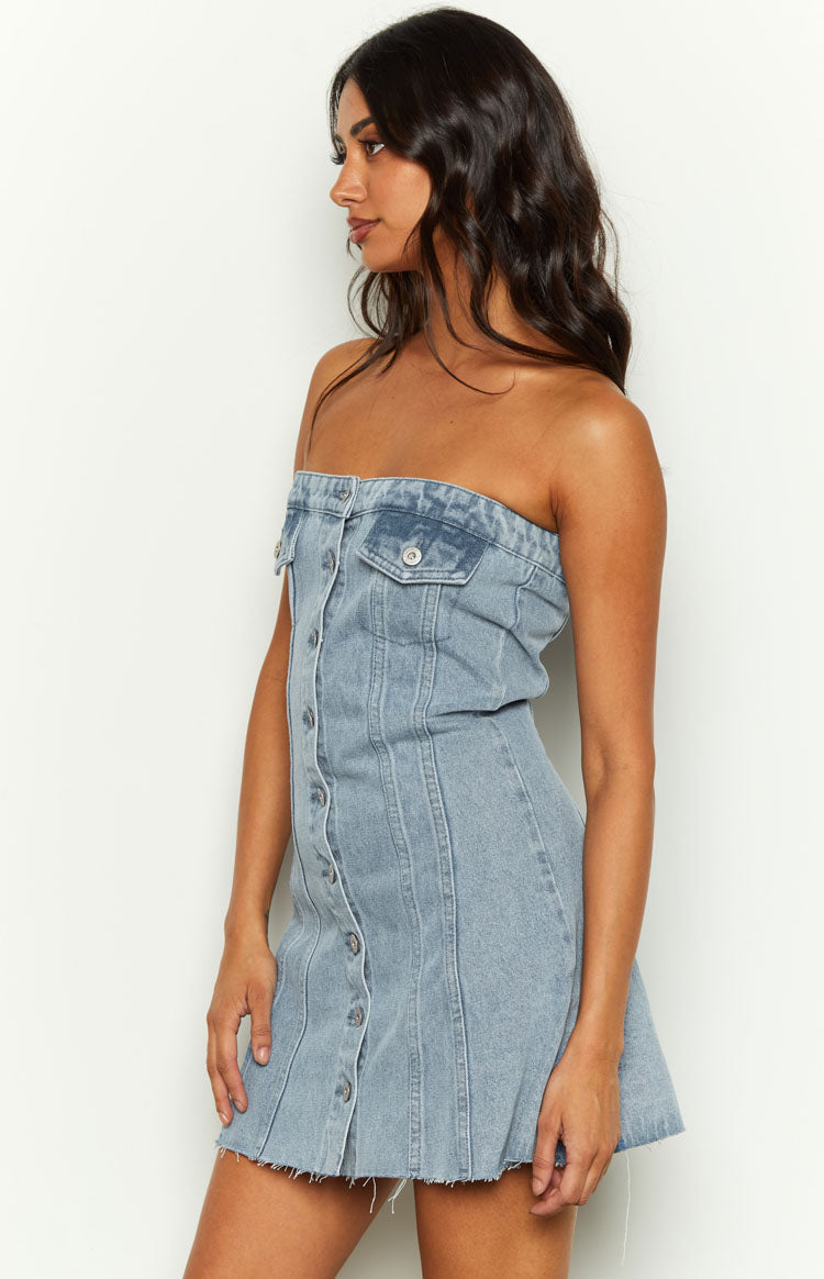 Side view of a light blue denim strapless mini dress with button-front closure and chest pockets