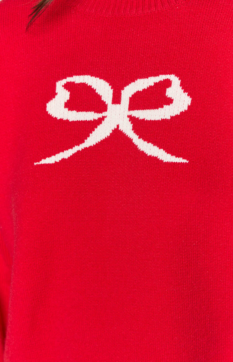 Close-up of the white knitted bow design on a red sweater