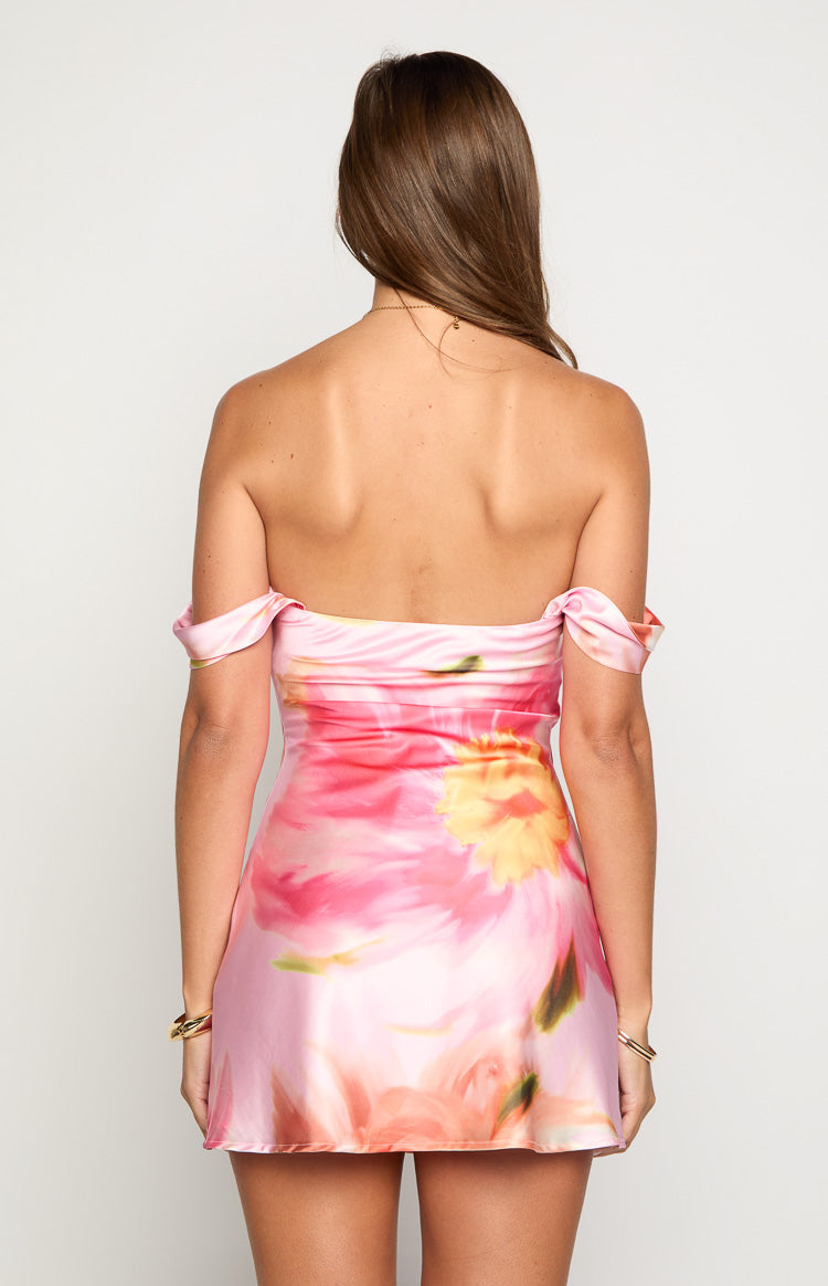 Rear view of a pink floral off the shoulder mini dress with draped sleeves and a fitted bodice