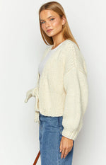 Rear view of a cream chunky knit cardigan with a deep V-back and tie-up detail forming a bow