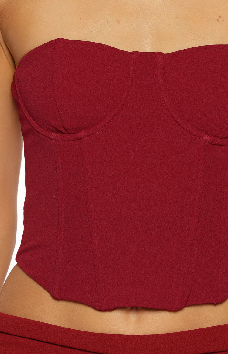 Close-up of the burgundy strapless corset top showing the sweetheart neckline and pointed front hem