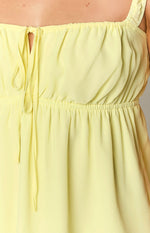 Close-up of the yellow mini dress showing the square neckline with a central drawstring tie and elasticated waist