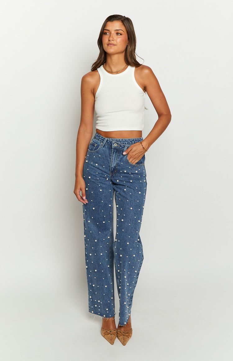 Mid wash blue high waisted jeans with scattered pearl embellishments and a straight leg fit