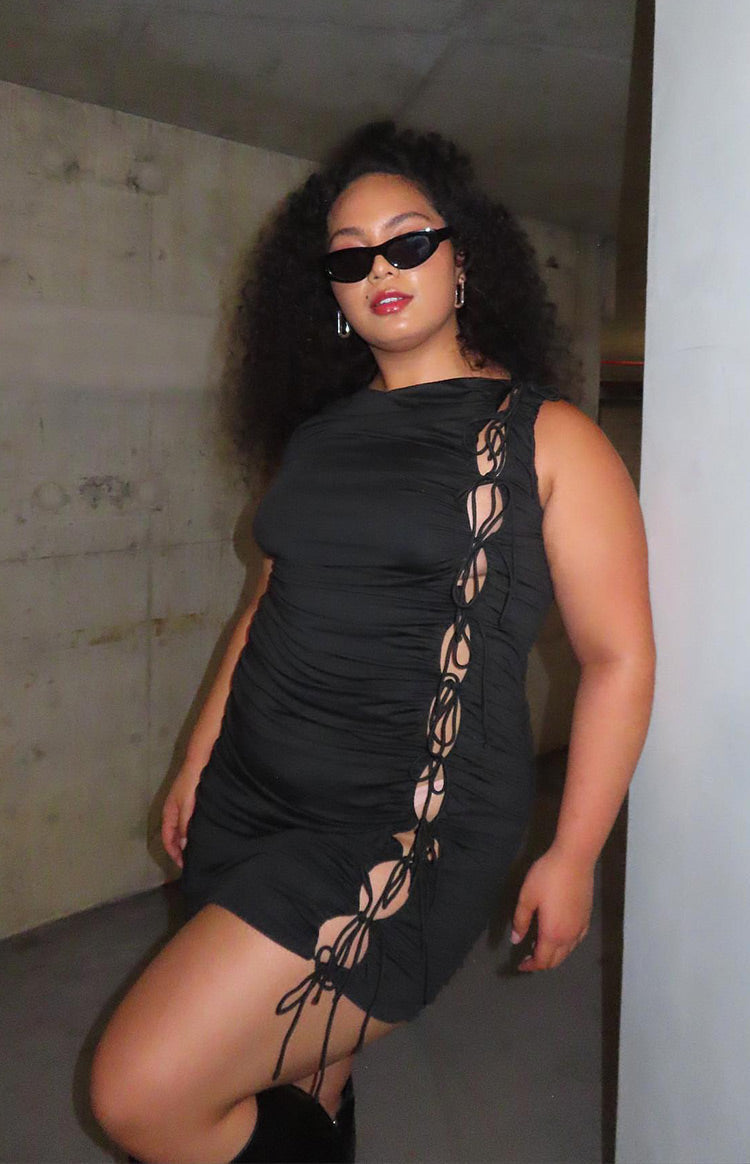 Black sleeveless mini dress with a high neckline and extensive side ruching with tie-up cutouts