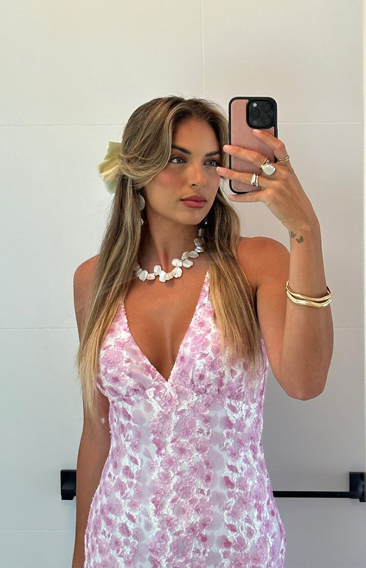 Side view of a pink lace maxi dress with a low scoop back and fitted bodycon silhouette