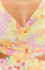 Close-up of the yellow floral print mini dress showing the V-neckline and crossover wrap bodice